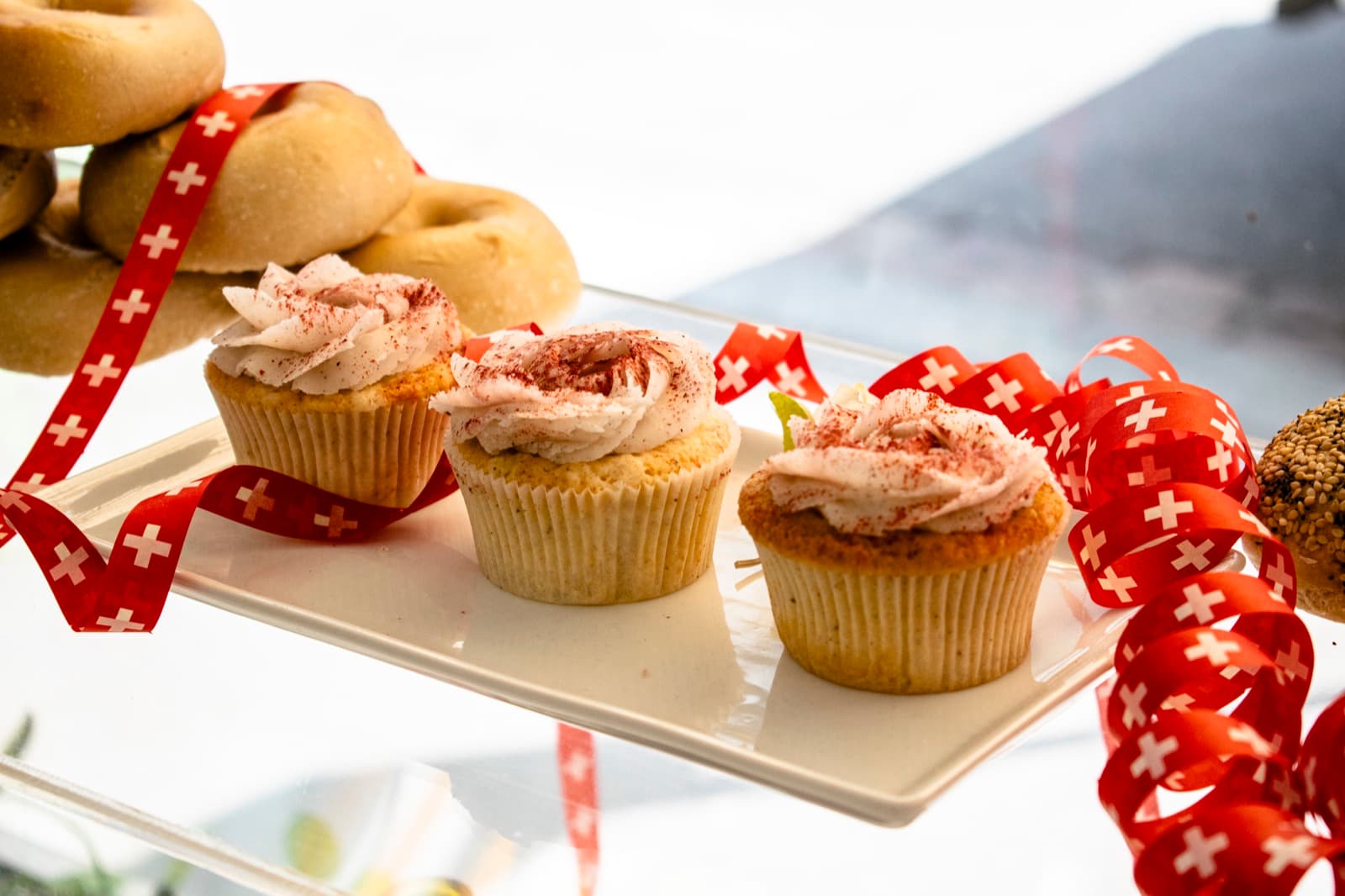 Cupcakes mit Frosting neben frischen Bagels