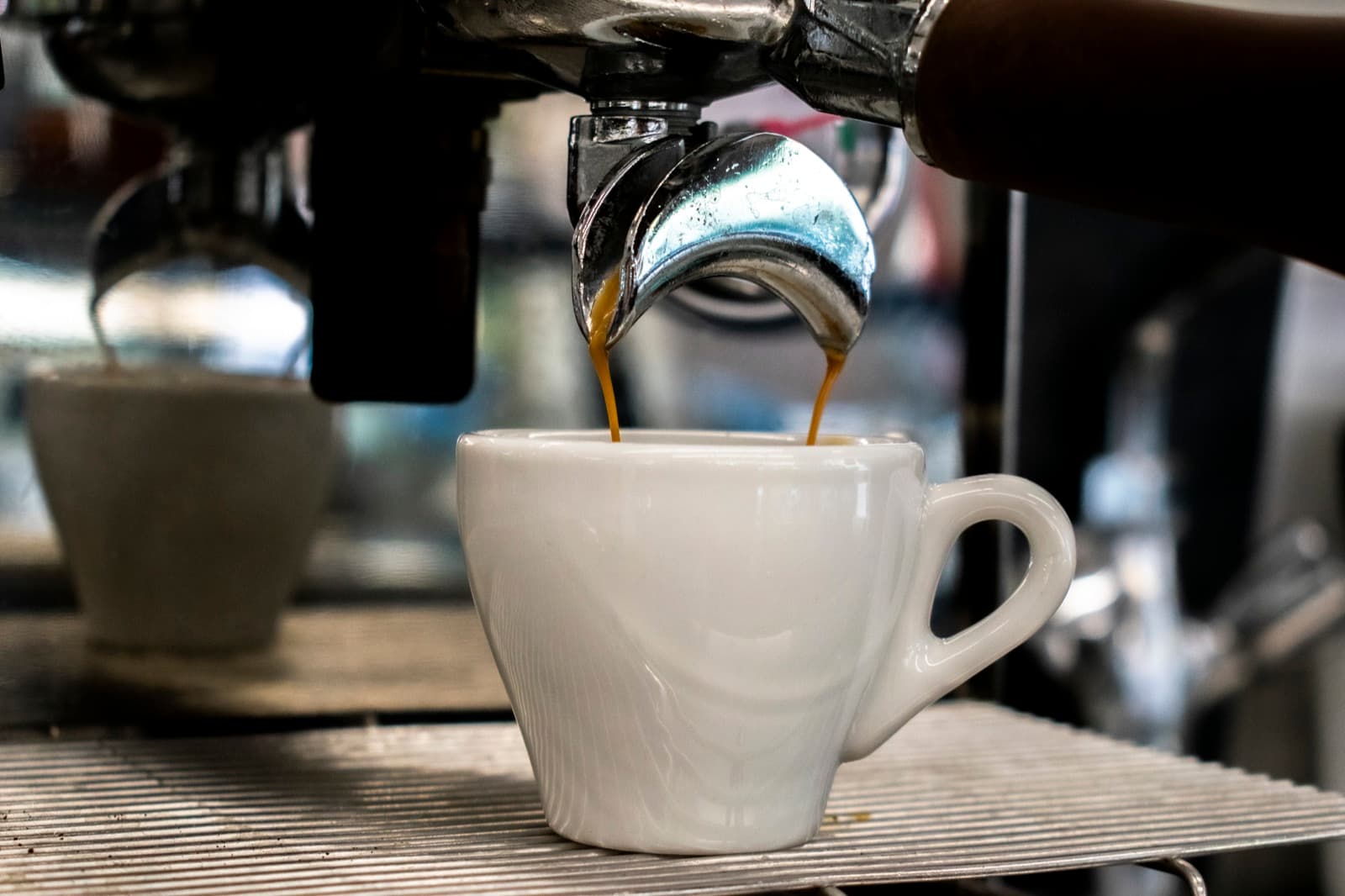 Espresso läuft frisch gebrüht in eine Tasse